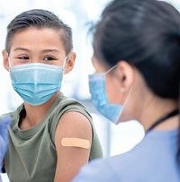 boy with bandaid on his arm after receiving vaccination