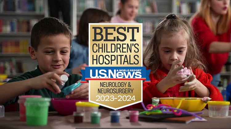 two neurodivergent children play in a classroom.