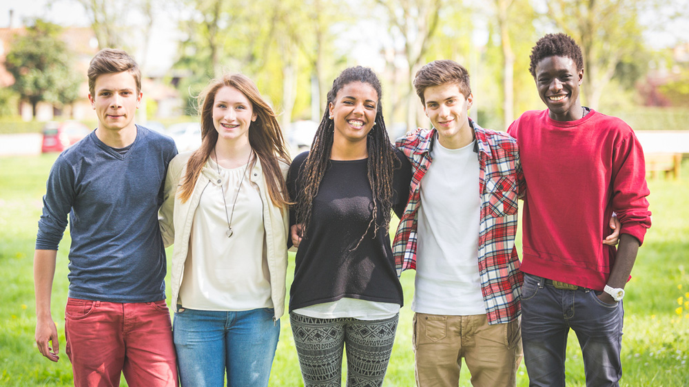 group of teenage boys and girls standing together.