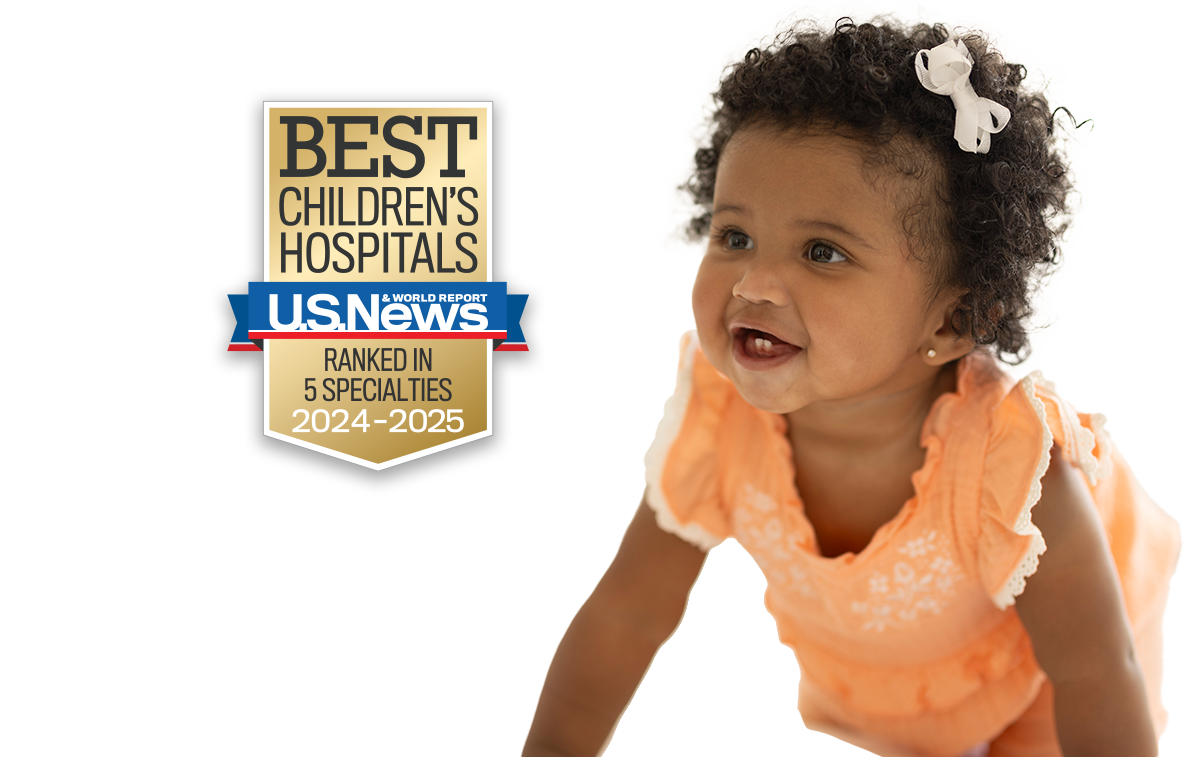 dark skinned baby girl wearing a frilly orange shirt.