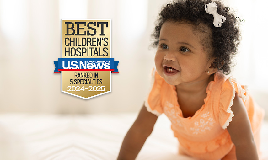 dark skinned baby girl wearing a frilly orange shirt.