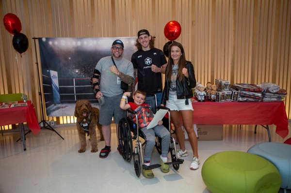 Atletas de la UFC con un niño en silla de ruedas